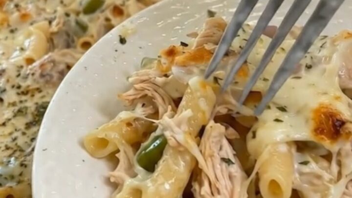 A fresh portion of Mississippi chicken casserole served on a white plate next to the baking dish.