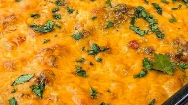 A warm, bubbly Mexican trash casserole in a glass dish garnished with fresh cilantro and showing a cheese pull