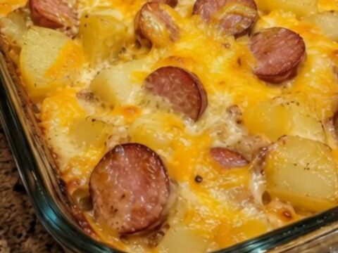 A bubbling, golden-brown sausage potato bake casserole fresh from the oven in a glass baking dish.