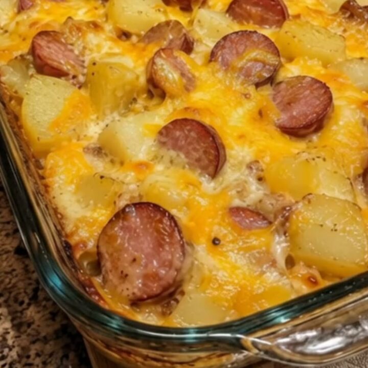 A bubbling, golden-brown sausage potato bake casserole fresh from the oven in a glass baking dish.