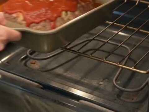 A golden-brown Italian meatloaf topped with a glossy red glaze, sliced to reveal a tender interior.