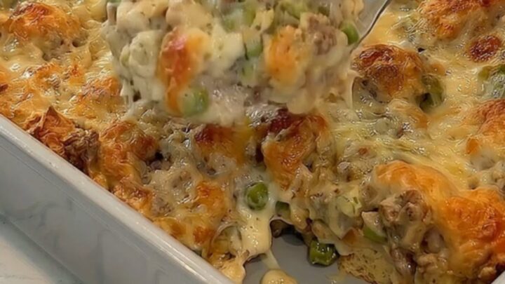 A warm, golden Philly cheesesteak bubble up casserole in a baking dish with a rich, stretchy cheese pull.