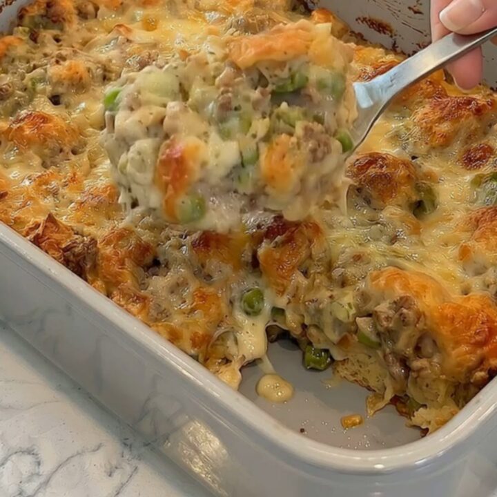 A warm, golden Philly cheesesteak bubble up casserole in a baking dish with a rich, stretchy cheese pull.