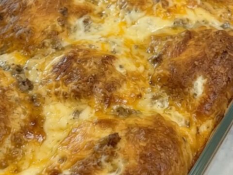 Vue rapprochée d'une part de casserole de biscuits dorée avec du fromage fondant qui s'étire.