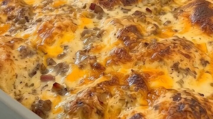 Une casserole de petit-déjeuner dorée avec du fromage fondant dans un plat en céramique.
