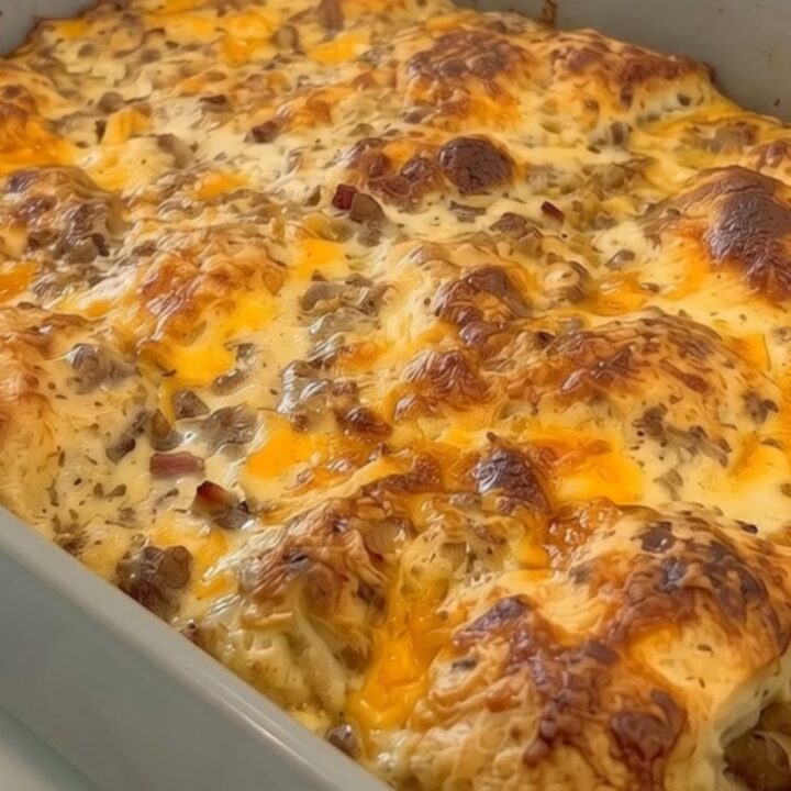 Une casserole de petit-déjeuner dorée avec du fromage fondant dans un plat en céramique.