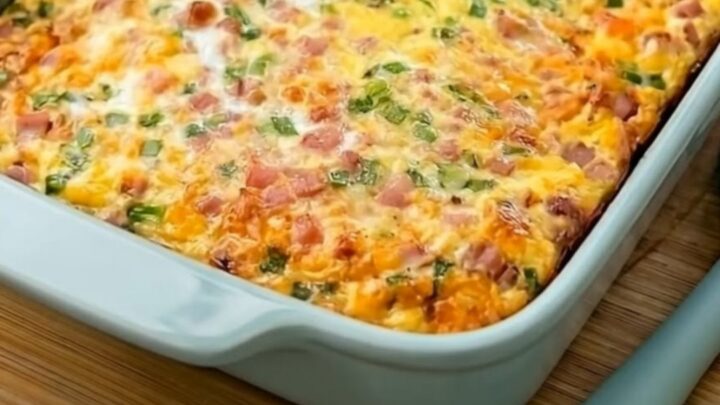 Une casserole de petit-déjeuner dorée avec des œufs, du jambon et du fromage fondu dans un plat bleu.