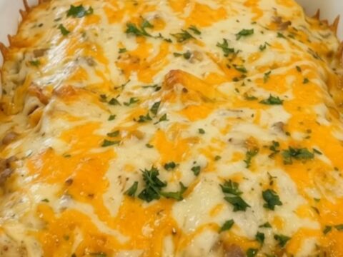 Vue rapprochée d'une enchilada de petit-déjeuner servie avec une sauce onctueuse et du fromage fondant.