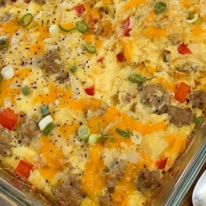 Gratin d'œufs moelleux dans un plat en verre avec fromage fondu et ciboule.