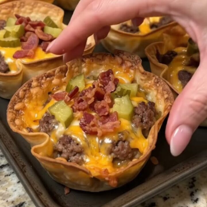 Gros plan sur une coupelle de tortilla dorée, garnie de bœuf haché, de cheddar fondu et de bacon croustillant.