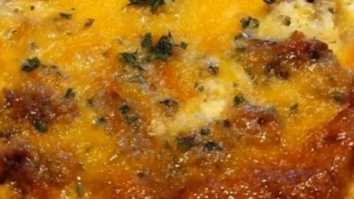 Une casserole de petit-déjeuner dorée et fondante dans un plat en verre avec du fromage fondu.