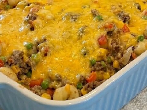 A slow push-in shot of the finished shipwreck casserole in a light blue ribbed baking dish on a kitchen counter