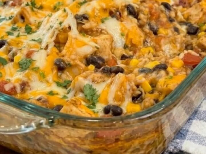 A scoop of cheesy Mexican chicken casserole being lifted from a baking dish, showing a long cheese pull.