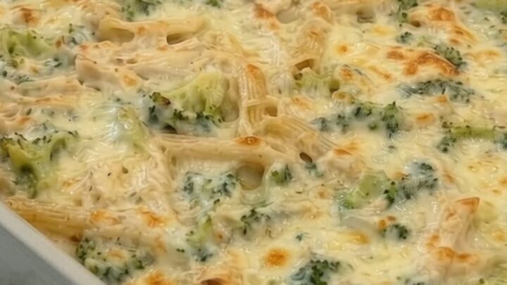 A hot, fresh dump-and-bake chicken Alfredo broccoli pasta casserole in a gray ceramic baking dish on a marble counter.