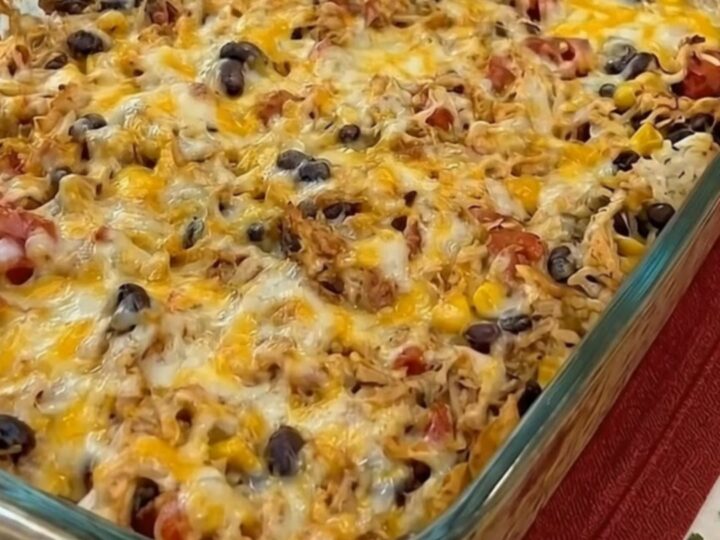 A spatula scooping a portion of cheesy chicken burrito casserole showing an epic melted cheese pull.