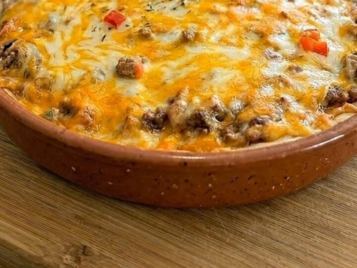 A hearty slice of cheesy beef burrito pie being lifted with a spatula, showing an epic melted cheese pull.