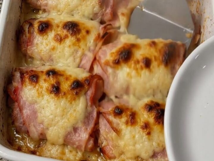 Roulés au jambon et fromage dorés et bouillonnants dans un plat blanc
