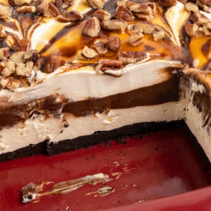 A decadent slice of layered sugar-free turtle lush dessert with glistening chocolate and caramel drizzles and toasted pecans