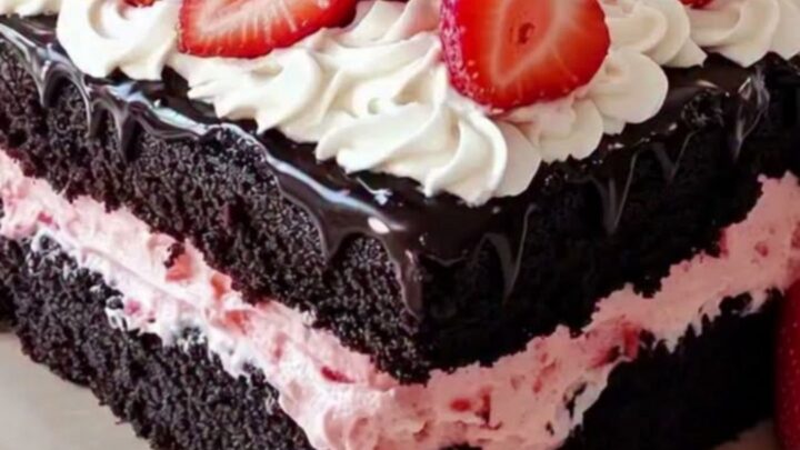 Gâteau carré au chocolat avec une couche de crème rose à la fraise et des décorations en chantilly sur le dessus.