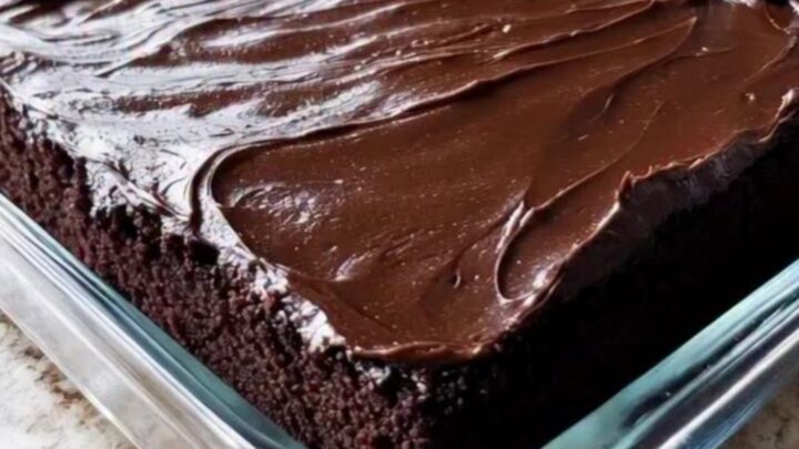 Gâteau au chocolat Wacky Cake glacé et brillant dans son plat en verre.