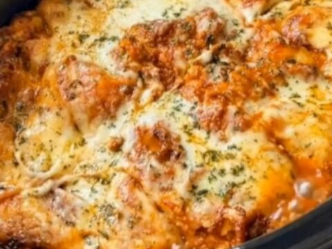 A deep slice of slow cooker lasagna being lifted with a spatula, creating a long