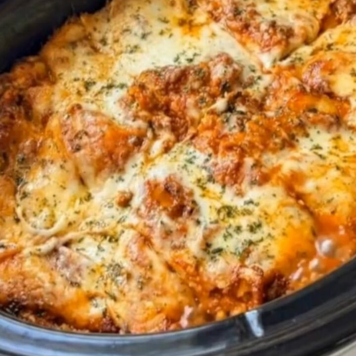 A deep slice of slow cooker lasagna being lifted with a spatula, creating a long