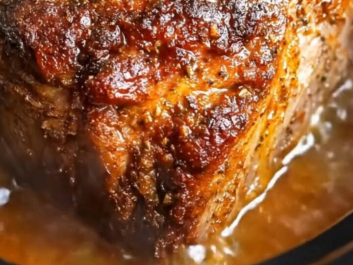 A succulent maple mustard pork roast served on a white plate with a glossy glaze.