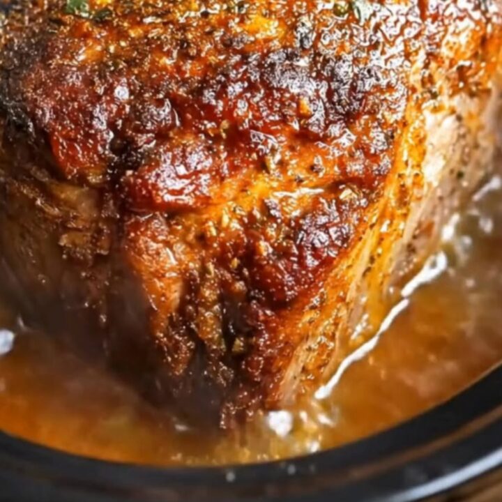 A succulent maple mustard pork roast served on a white plate with a glossy glaze.