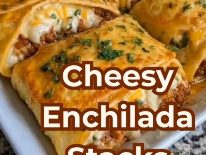 A spatula lifting a cheesy, layered beef enchilada stack from a white baking dish.