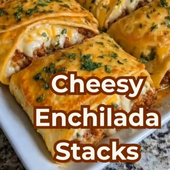 A spatula lifting a cheesy, layered beef enchilada stack from a white baking dish.