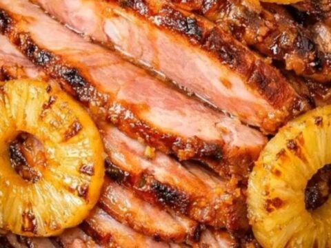 A succulent spiral-cut ham glazed with caramelized brown sugar and pineapple rings in a slow cooker.