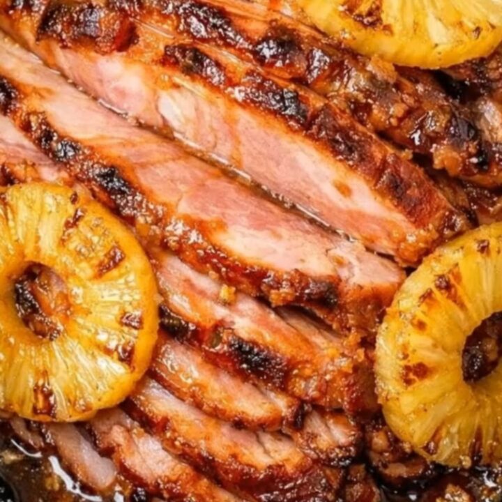 A succulent spiral-cut ham glazed with caramelized brown sugar and pineapple rings in a slow cooker.