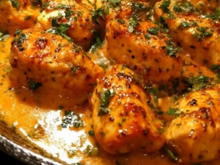 Golden seared chicken bites in a cast-iron skillet, topped with fresh parsley and a rich garlic butter sauce.
