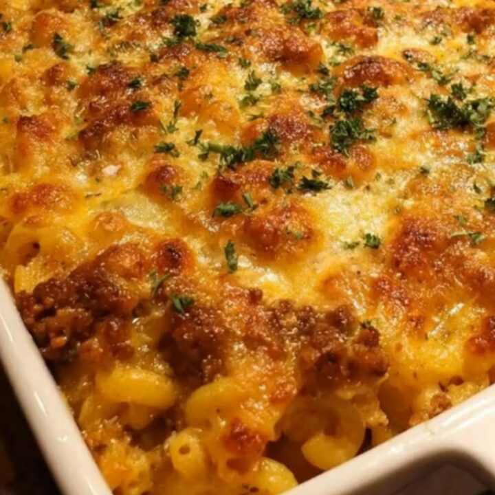 A golden-brown cheesy mac and cheese meatloaf bake in a white baking dish.