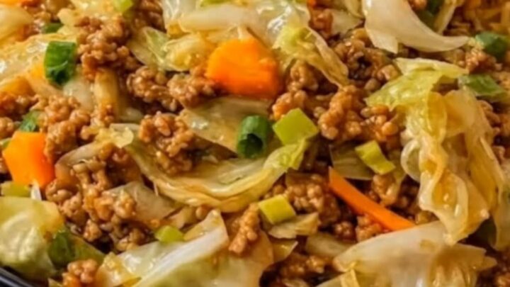 A steaming portion of beef and cabbage stir fry in a black skillet.