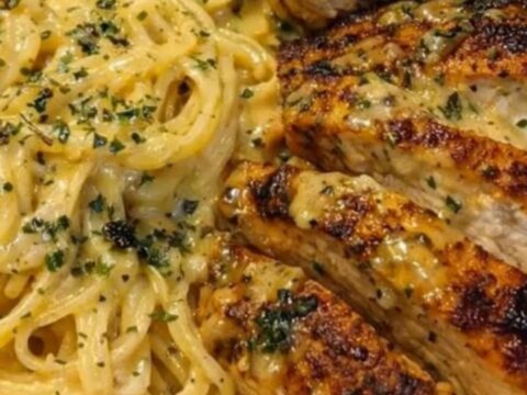 A shallow bowl filled with creamy garlic butter chicken spaghetti and golden seared chicken strips.