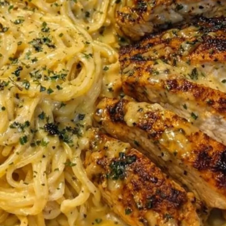 A shallow bowl filled with creamy garlic butter chicken spaghetti and golden seared chicken strips.