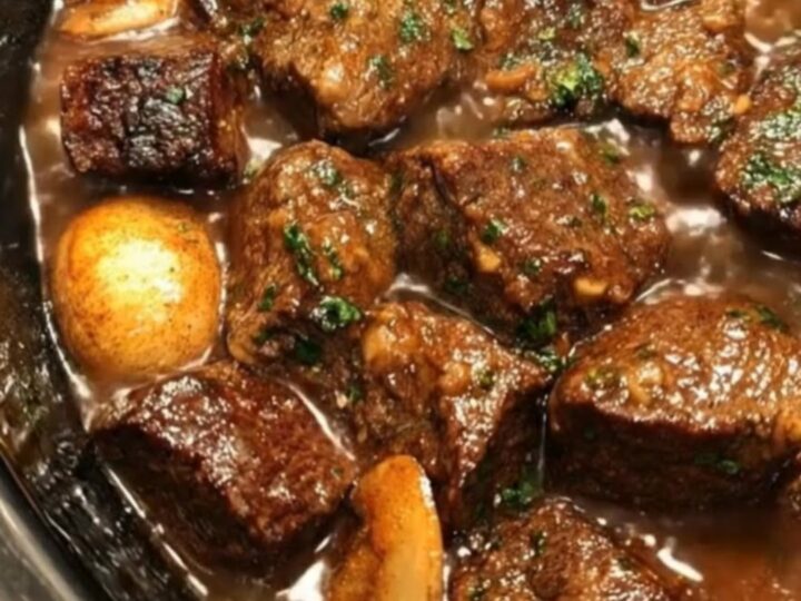 A warm, hearty bowl of tender slow cooker beef tips and mushrooms covered in a rich, glossy brown gravy.