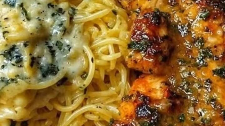 A close-up of creamy parmesan spaghetti topped with golden-brown seared chicken pieces.