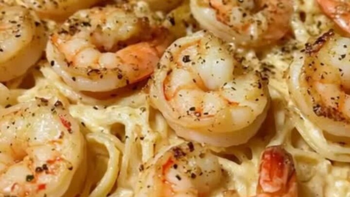 A twirl of creamy linguine pasta topped with a succulent, golden-seared jumbo shrimp and fresh parsley.