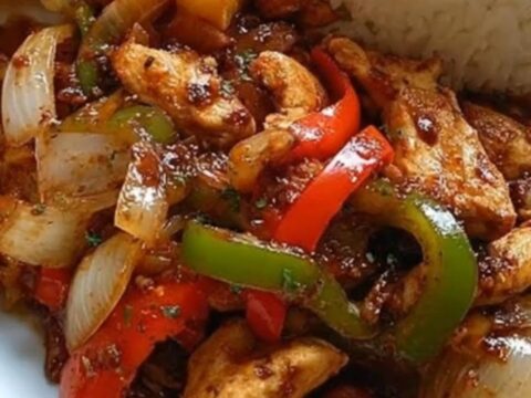 A plate featuring chicken stir-fry with peppers, crispy golden potato wedges, and a neat dome of white rice.