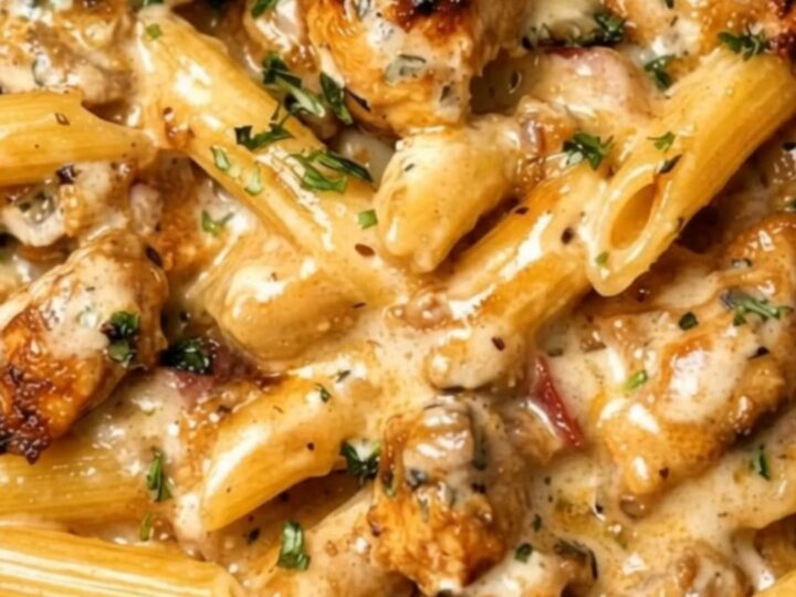 A steaming bowl of creamy garlic butter chicken penne garnished with fresh chopped parsley.