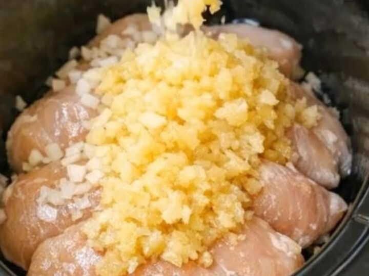 A close-up of tender chicken breasts covered in a glossy pineapple sauce on a white plate.