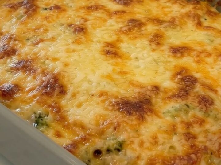 A golden, bubbly potato and broccoli casserole in a grey ceramic dish.