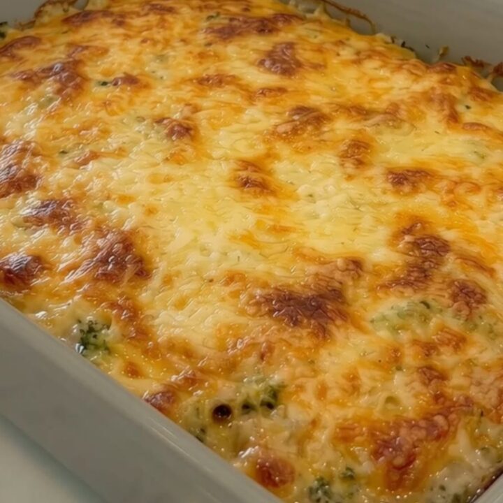 A golden, bubbly potato and broccoli casserole in a grey ceramic dish.