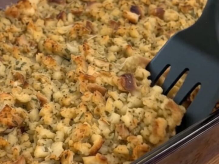 A golden-brown creamy chicken and stuffing casserole in a glass baking dish.