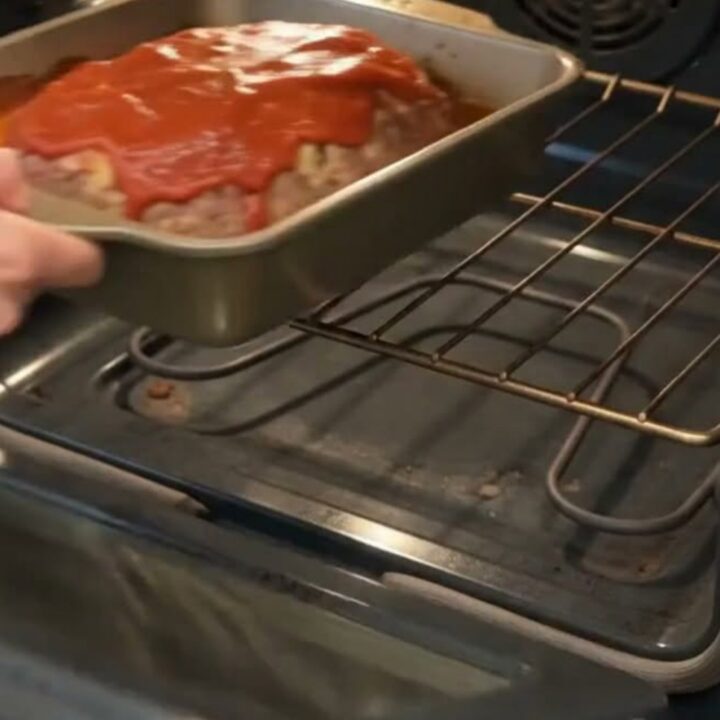 Juicy Italian meatloaf slice with a glossy tomato glaze served on a clean white dinner plate.