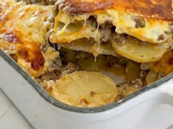 A golden, cheesy potato and ground beef casserole in a white ceramic dish.