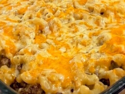 A warm, hearty slice of mac and cheese meatloaf casserole served on a white plate.