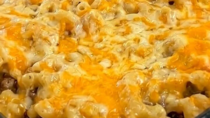 A warm, hearty slice of mac and cheese meatloaf casserole served on a white plate.